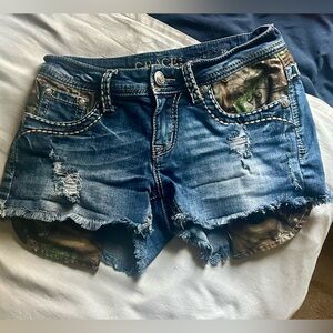 Grace in LA Blue Distressed Jean Shorts with Camo Accents